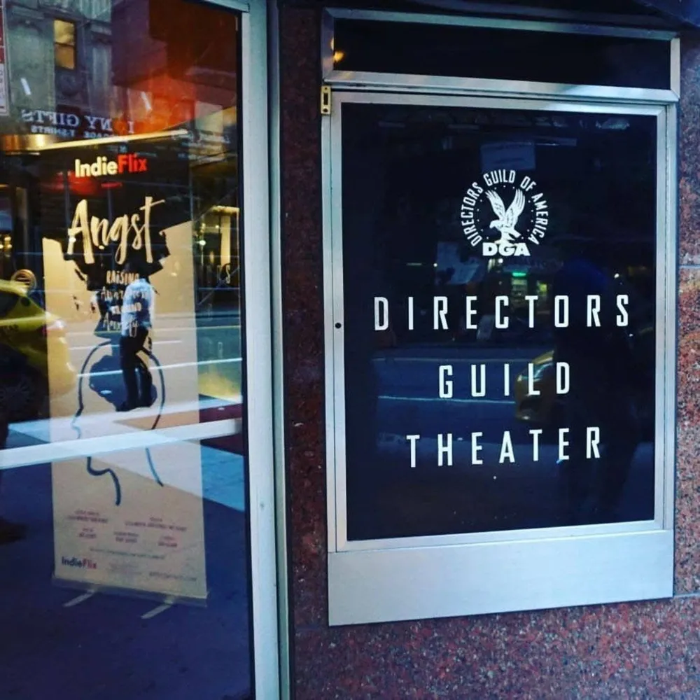 An Angst poster in the glass doors of the Directors Guild Theater, beside the theater’s sign.