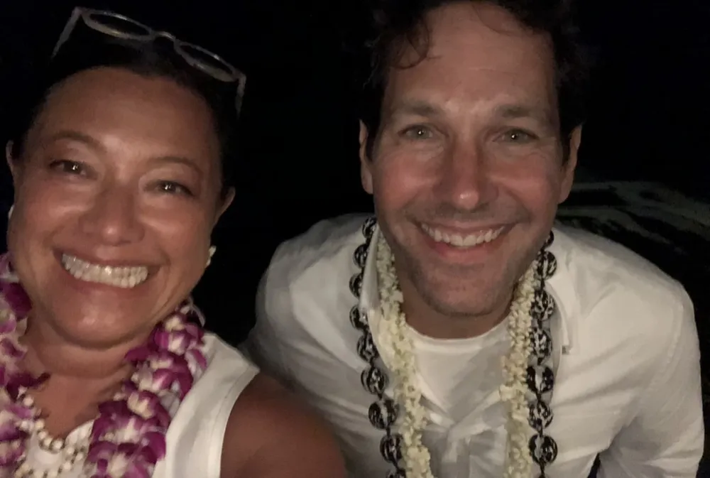 A night-time selfie of Scilla and Paul Rudd, both smiling and wearing leis.