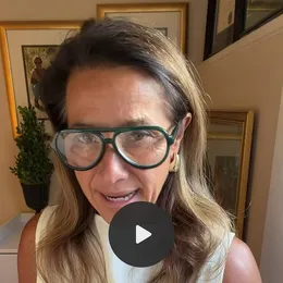 A still from Scilla’s video: Scilla in green-rimmed glasses, talking to the camera at home.